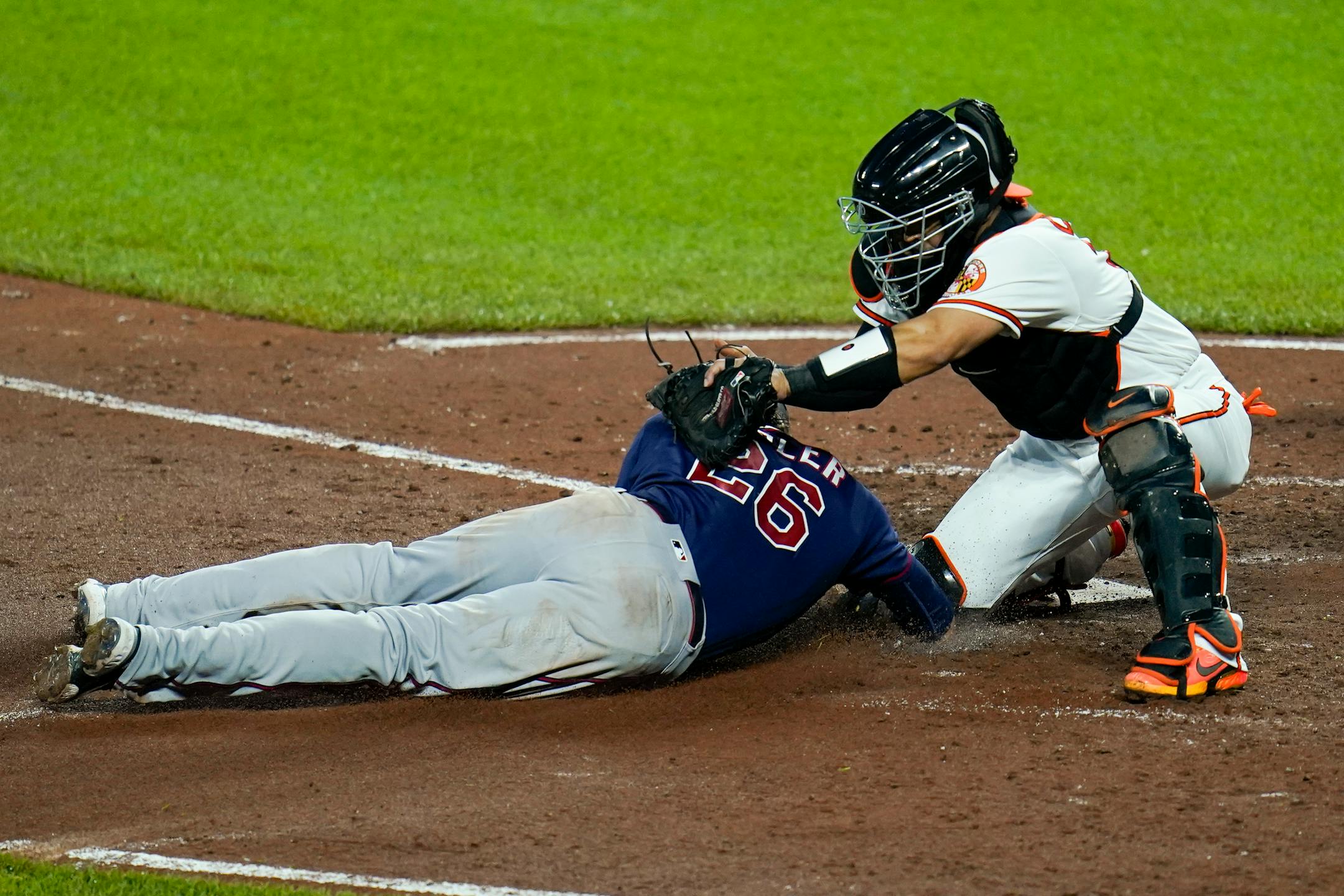 Baltimore Orioles catcher Robinson Chirinos, right, tags out Minnesota Twins' Max Kepler trying to score on a double by Gary Sanchez during the fourth inning of a baseball game, Thursday, May 5, 2022, in Baltimore. (AP Photo/Julio Cortez)