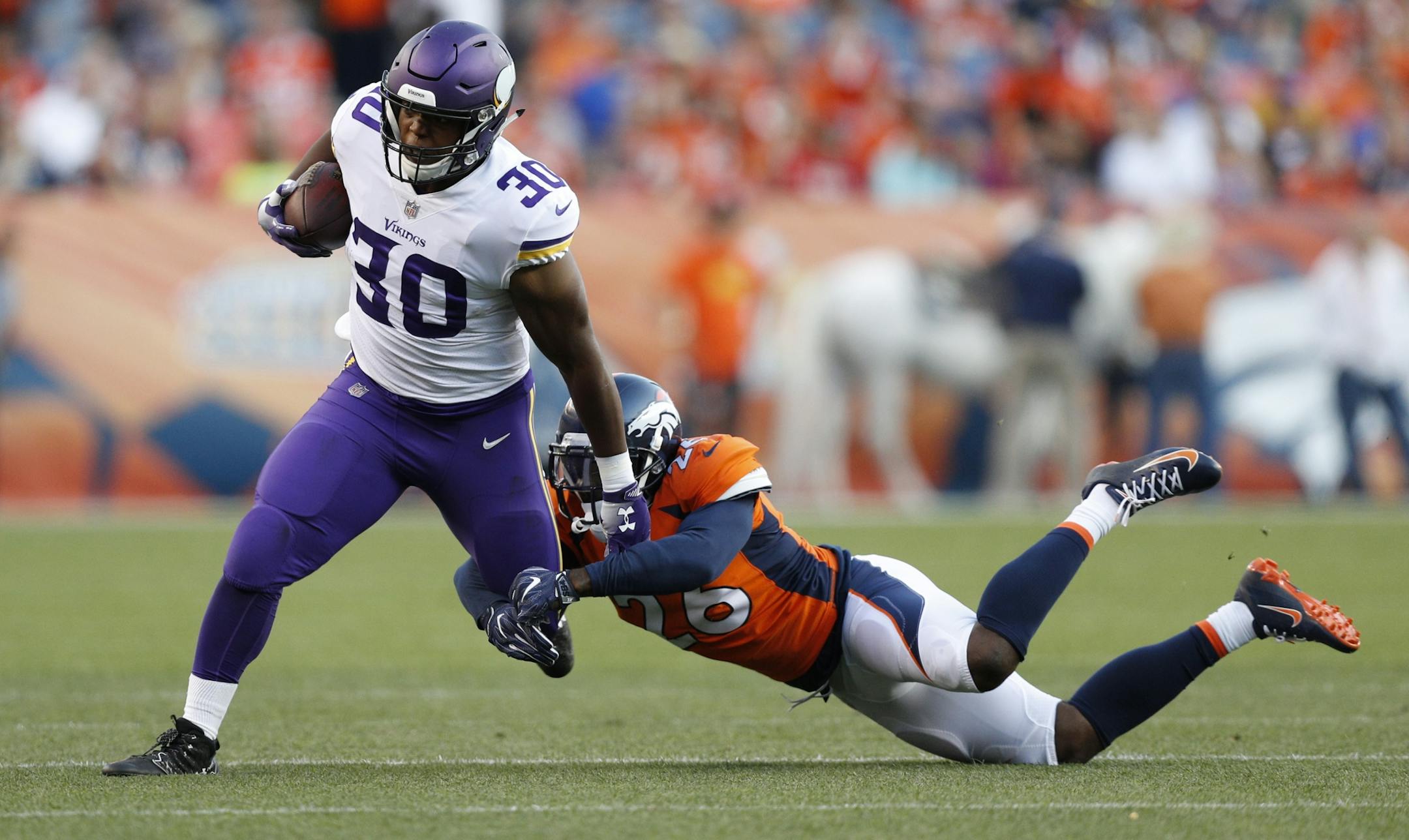 Minnesota Vikings fullback C.J. Ham (30) picked up 6 yards in the first quarter and was tackled by Denver Broncos defensive back Darian Stewart (26) Saturday August 11, 2018 at Broncos Stadium at Mile High in Denver, CO.