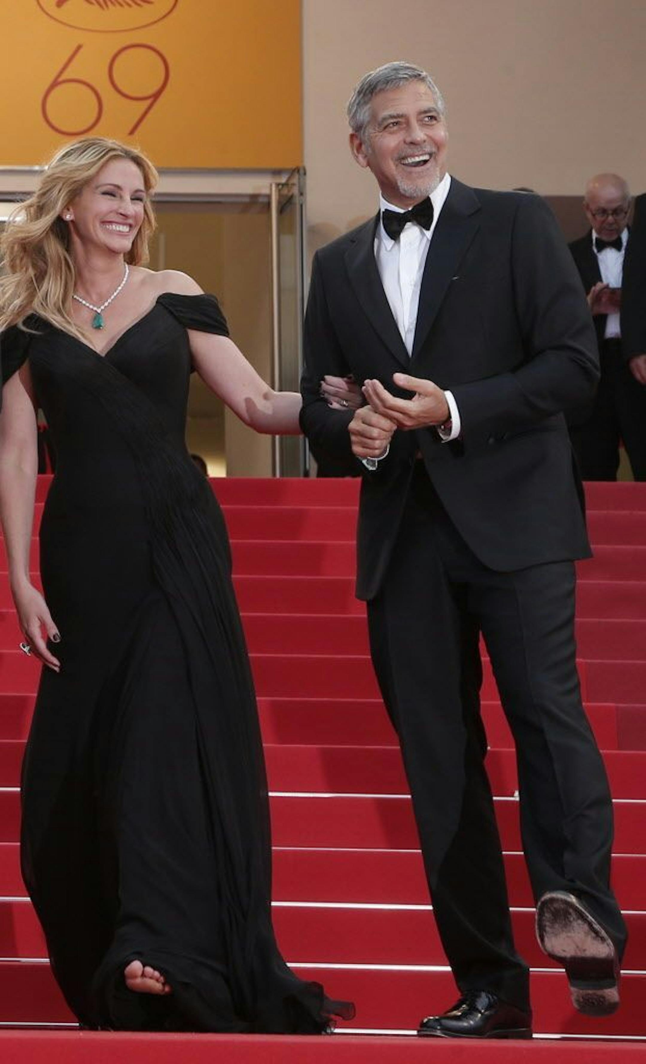 Actors Julia Roberts, left, and George Clooney pose for photographers for the screening of the film Money Monster at the 69th international film festival, Cannes, southern France, Thursday, May 12, 2016. Julia Roberts ascended the red carpet steps barefoot at the Cannes Film Festival.