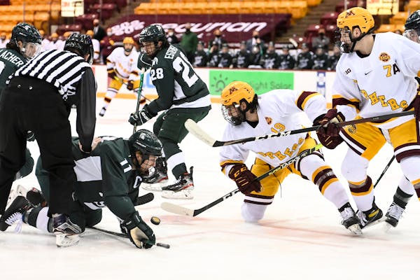 Minnesota Gophers forward Scott Reedy (19) and Michigan State forward Tommy Apap (11) battled for the puck after a face off in the first period. ] AAR
