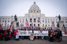 People posed with signs thanking law enforcement as Minnesota State troopers stood guard outside the Capitol during a rally supporting President Trump