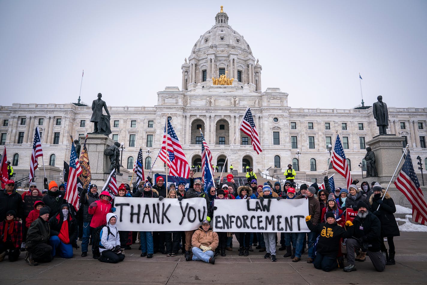 People posed with signs thanking law enforcement as Minnesota State troopers stood guard outside the Capitol during a rally supporting President Trump. ] LEILA NAVIDI • leila.navidi@startribune.com