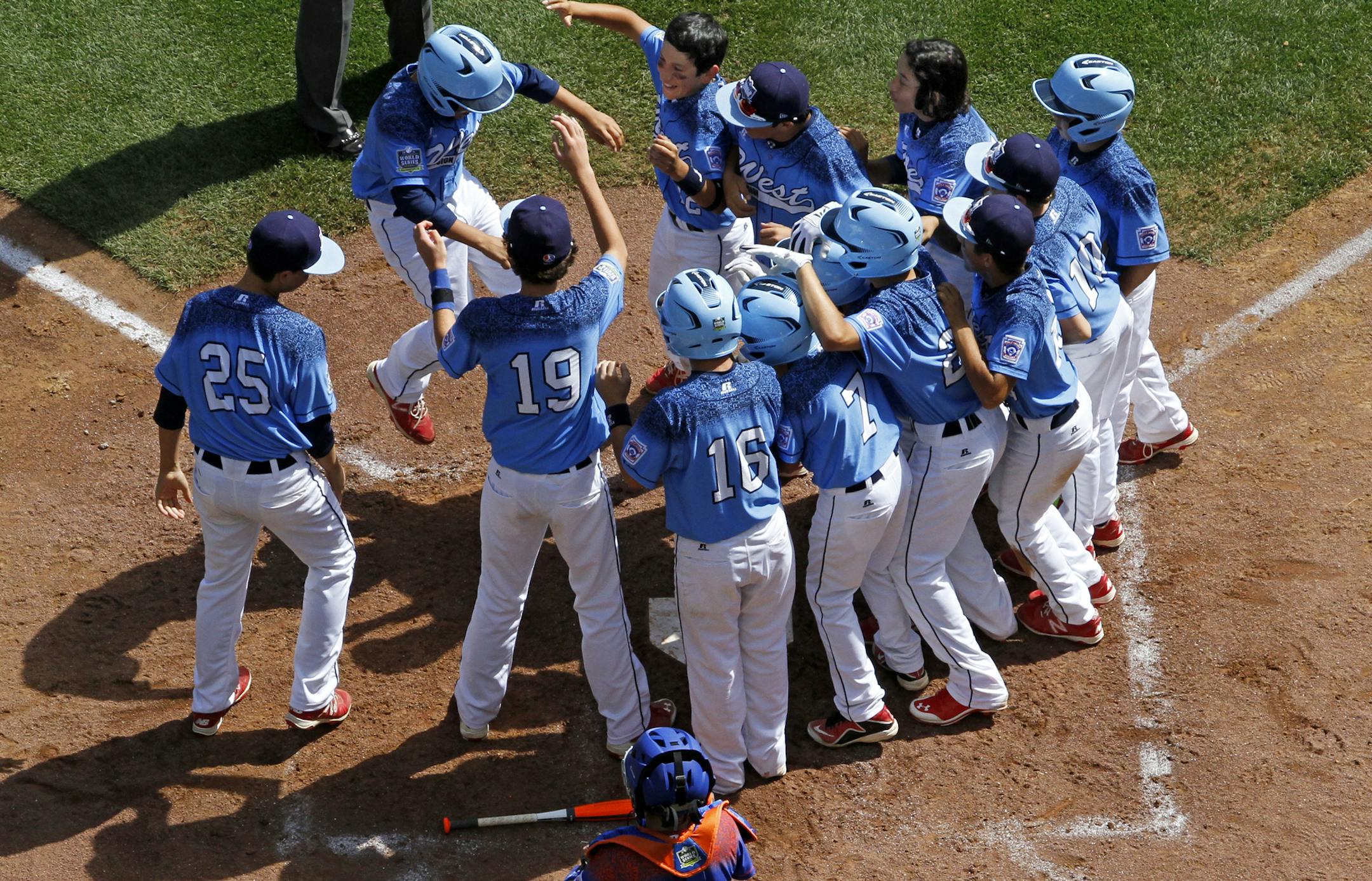 Bonita, California's Nick Maldonado, top left, leaps on home plate as he is swarmed by teammates after hitting a grand slam off Bowling Green, Kentucky's Ty Bryant during the third inning of a baseball game in United States pool play at the Little League World Series tournament in South Williamsport, Pa., Friday, Aug. 21, 2015. The West won 14-2. (AP Photo/Gene J. Puskar)