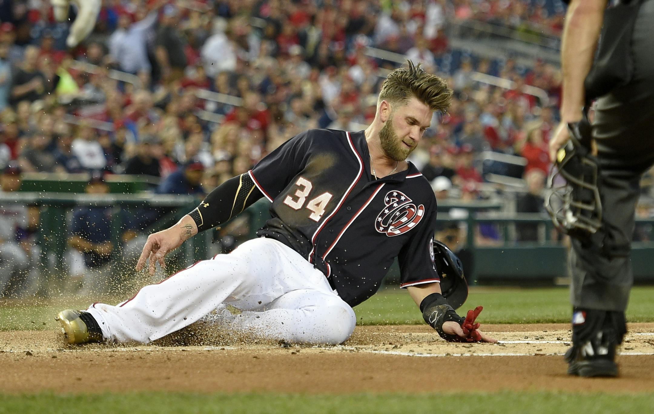 Washington Nationals' Bryce Harper slides home to score on a single by Daniel Murphy during the first inning of a baseball game against the Minnesota Twins, Friday, April 22, 2016, in Washington. (AP Photo/Nick Wass)