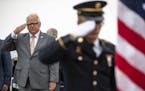 (Left) Governor Walz and River Demars, a specialist in the army and Minnesota National Guard, saluted the American Flag during the presentation of col
