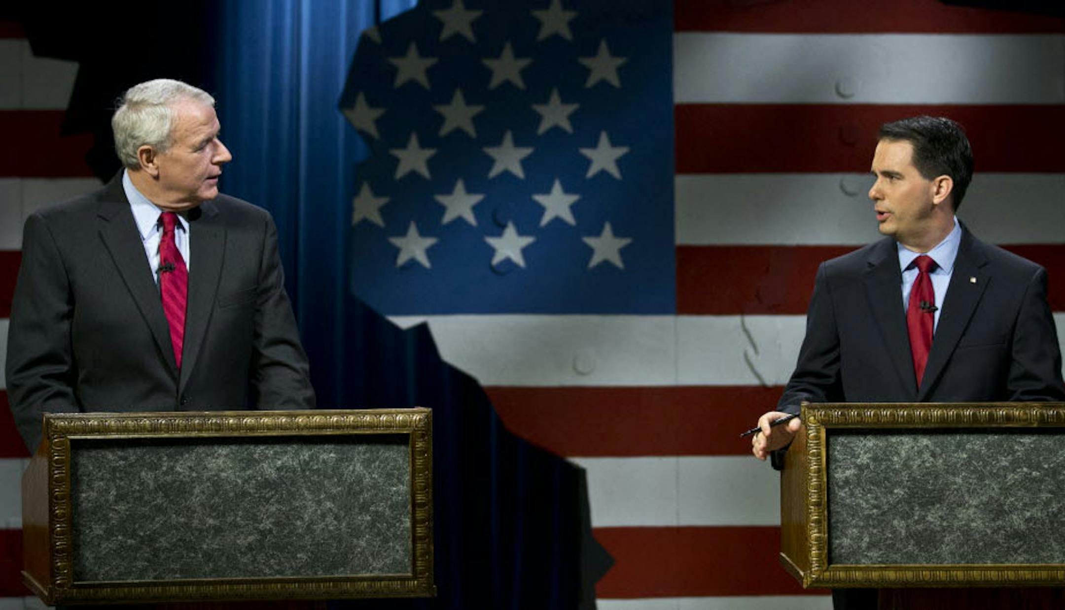 Republican Wisconsin Gov. Scott Walker, right, and Democratic challenger Tom Barrett get ready to participate in a televised debate Friday, May 25, 2012, in Milwaukee. Both candidates have been battling a numbers game for weeks, pointing to different statistics to make their points about the other candidate. How well they have done with the economy has been a major focus of the campaign and was expected to be highlighted during the debate as well. (AP Photo/Morry Gash) \
