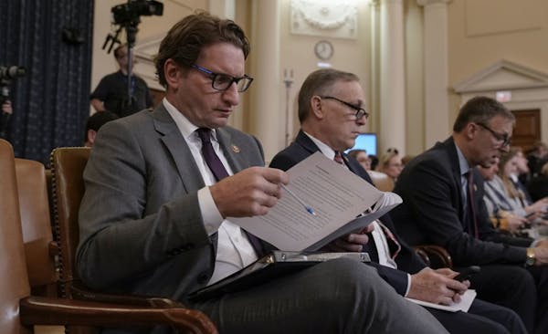 Rep. Dean Phillips, D-Minn., left, sits with Rep. Andy Biggs, R-Ariz., as they attend the House Intelligence Committee hearing with U.S. Ambassador to