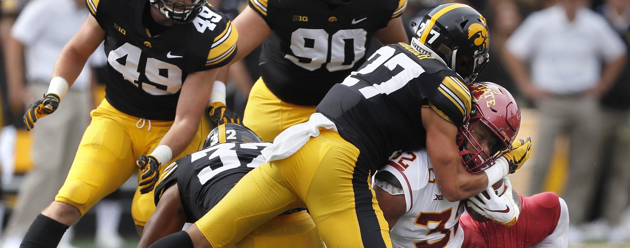 Iowa defensive back Amani Hooker, center, tackles Iowa State running back David Montgomery last month.