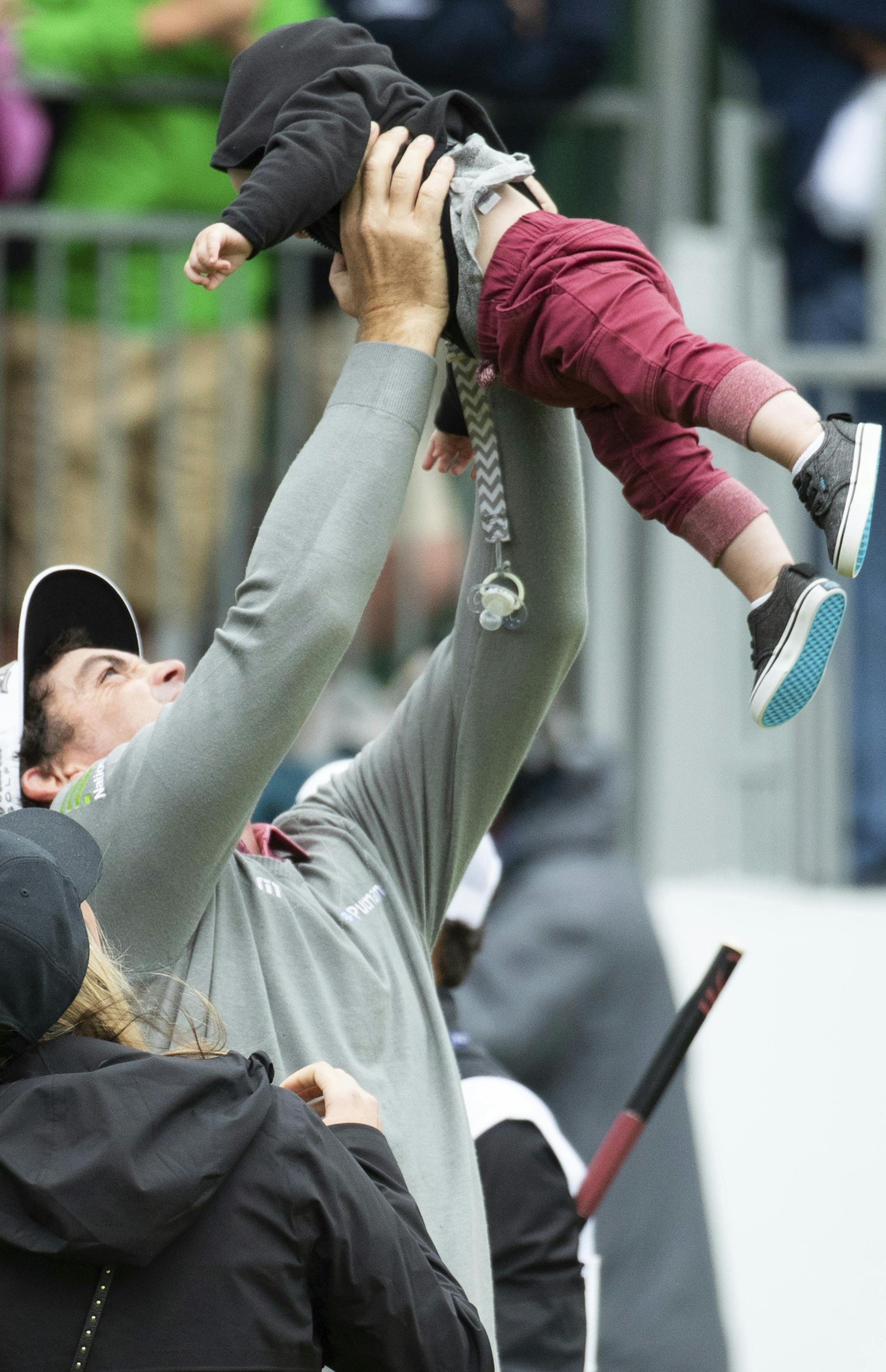 Keegan Bradley lefts up his son, Lugan, followiing the BMW Championship golf tournament at the Aronimink Golf Club, Monday, Sept. 10, 2018, in Newtown Square, Pa. Keegan Bradley held off Justin Rose in a sudden-death playoff to win the rain-plagued BMW Championship for his first PGA Tour victory in six years. (AP Photo/Chris Szagola)