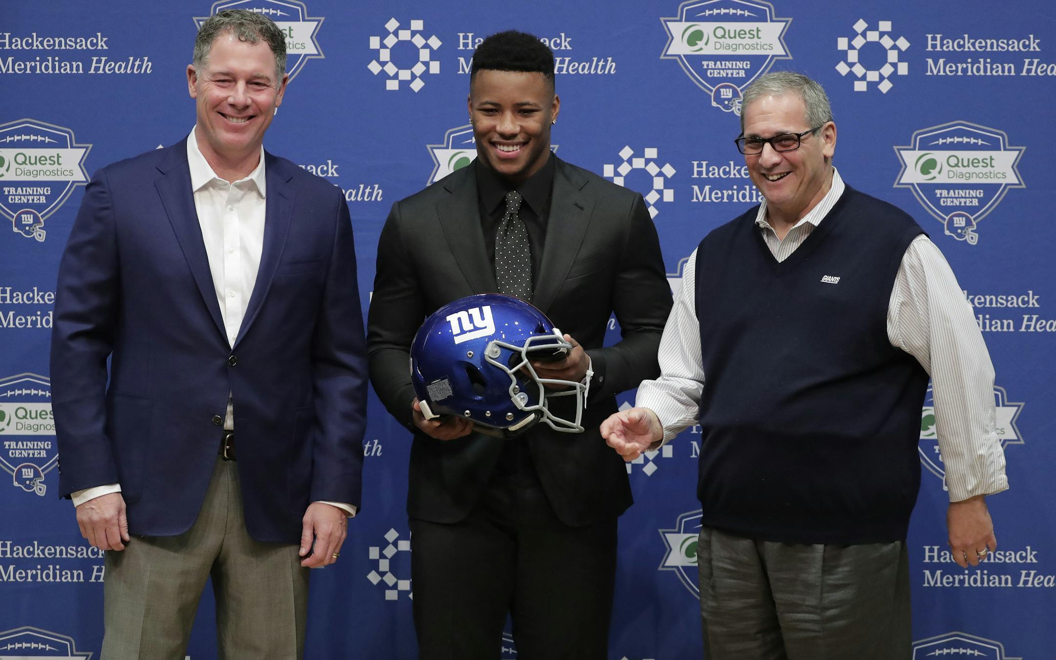New York Giants first round NFL football draft pick running back Saquon Barkley, center, poses for photos with Giants head coach Pat Shurmur, left, and general manager Dave Gentleman during a news conference, Saturday, April 28, 2018, in East Rutherford, N.J. Barkley was selected as the number two overall pick in the NFL football draft by the New York Giants. (AP Photo/Julie Jacobson)