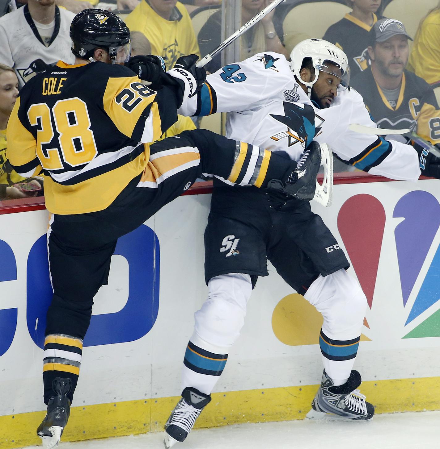 Pittsburgh Penguins' Ian Cole (28) checks San Jose Sharks' Joel Ward (42) into the boards during the first period in Game 1 of the Stanley Cup final series Monday, May 30, 2016, in Pittsburgh. (AP Photo/Gene J. Puskar)