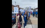 Members of the Minneapolis Federation of Teachers and Education Support Professionals picket Saturday morning outside Folwell Elementary School after 