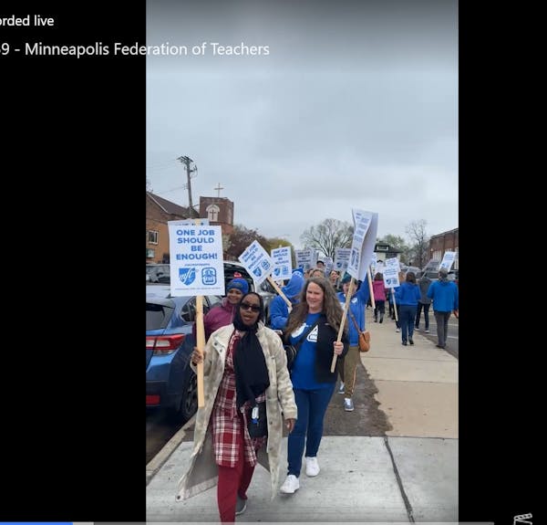 Members of the Minneapolis Federation of Teachers picket Saturday morning outside Folwell Elementary School after voting Friday night to authorize a s