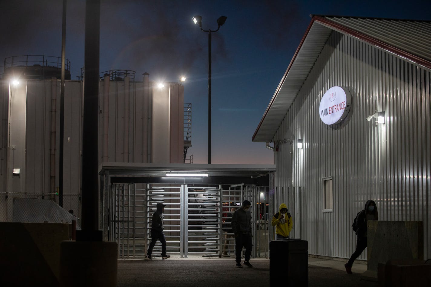 Young workers exit a JBS pork plant after an overnight cleaning shift in Worthington, Minn.