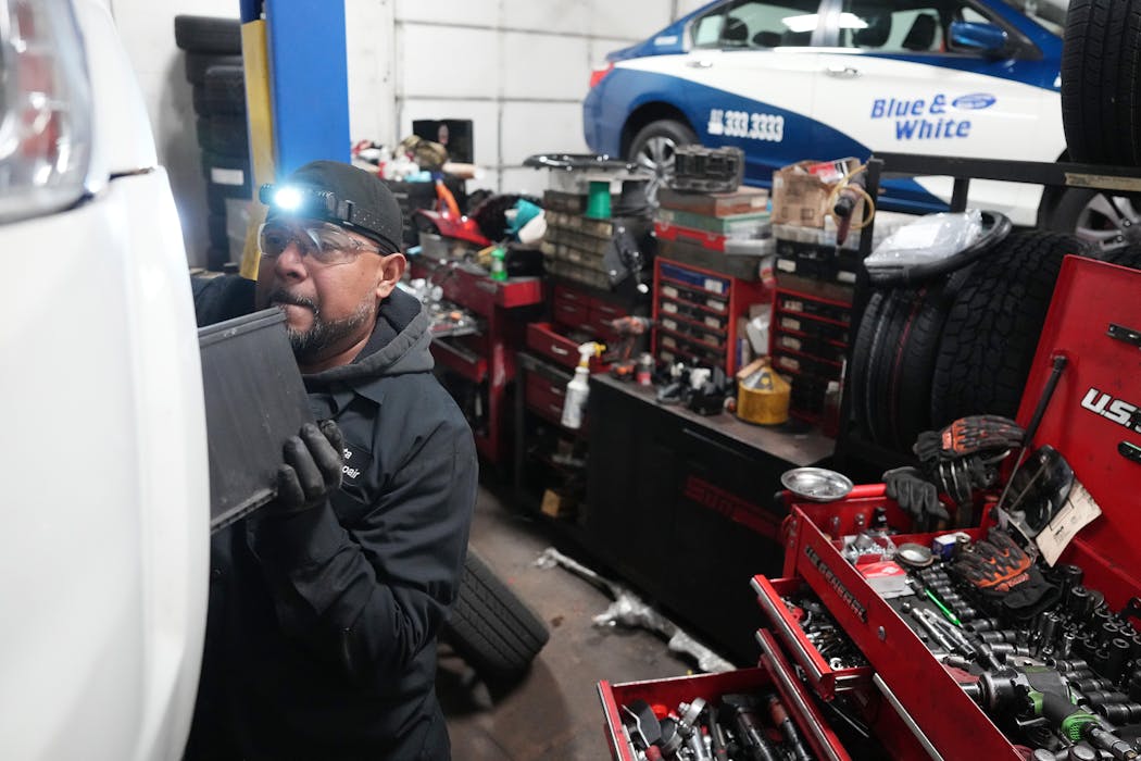 Mechanic Jesus Montes replaces the battery on a fleet vehicle at Blue and White Taxi in St. Louis Park on Wednesday. 