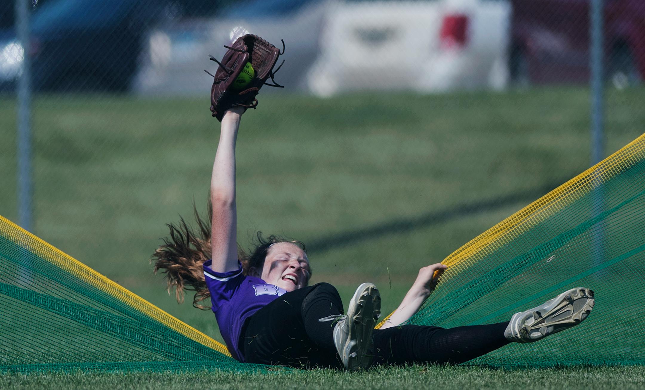 Buffalo outfielder Jordan Zrust (6) falls as she makes a catch to steal a home run in the third inning. Buffalo defeated Woodbury 3-1 in the state high softball tournament on Thursday.