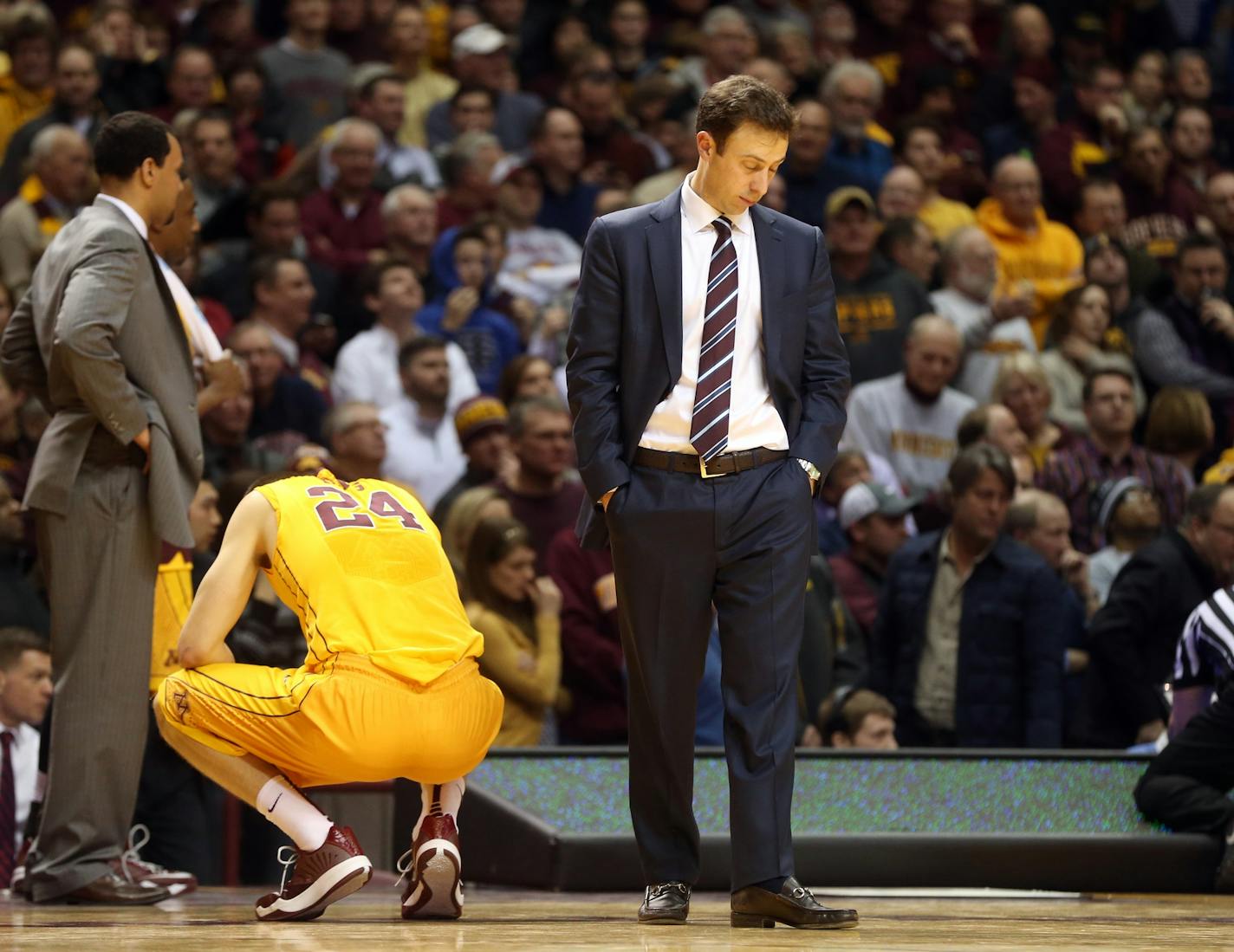 Minnesota head coach Richard Pitino looks at the floor as officials, right, review a last second basket which would have tied an NCAA college basketball game against Iowa, Tuesday, Jan. 13, 2015, in Minneapolis. Officials ruled time had run out and Iowa won 77-75. (AP Photo/Jim Mone)