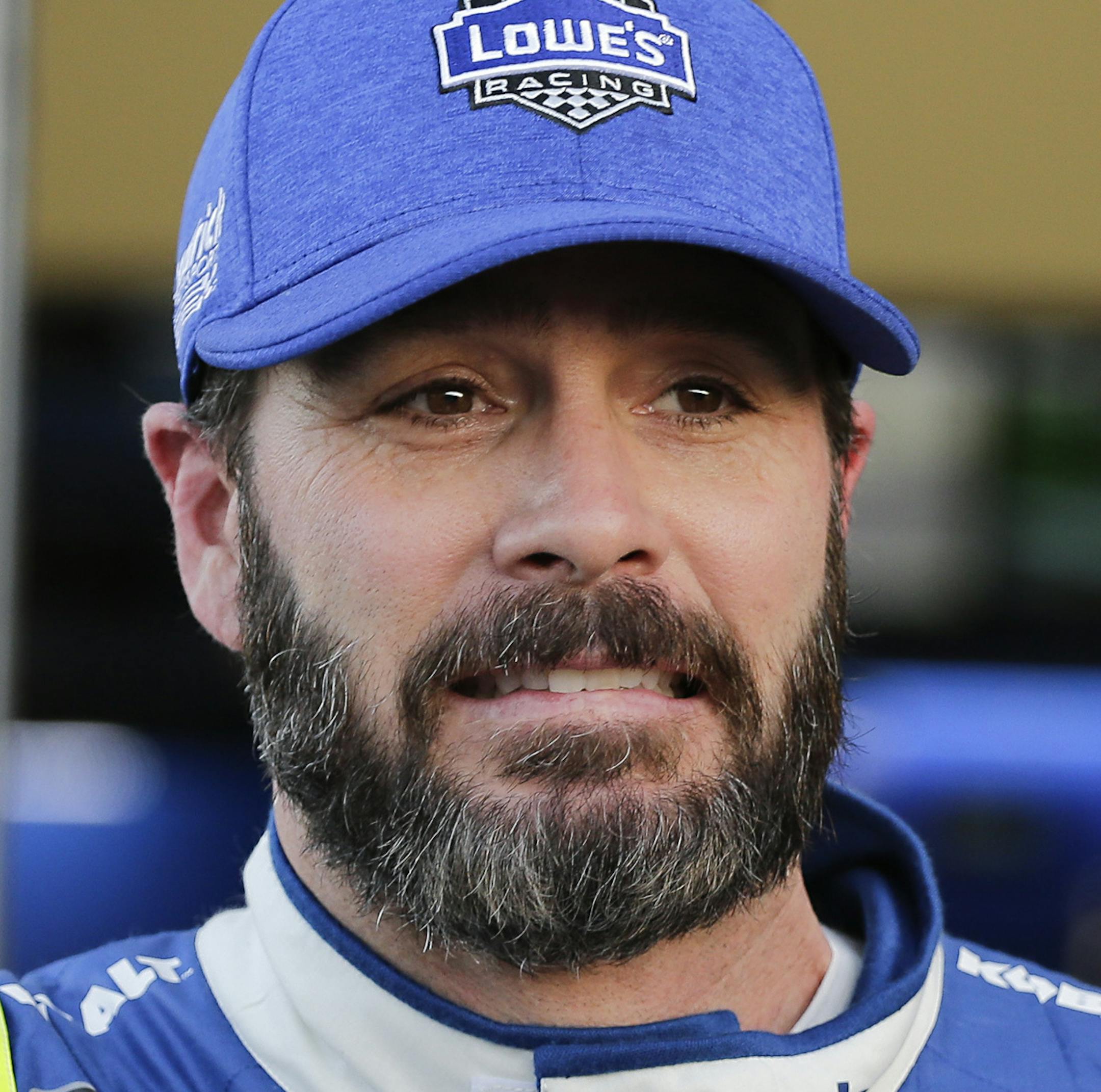 Jimmie Johnson, left, talks with a team member outside his garage during a practice session for the Clash NASCAR auto race at Daytona International Speedway, Friday, Feb. 17, 2017, in Daytona Beach, Fla. (AP Photo/Terry Renna)