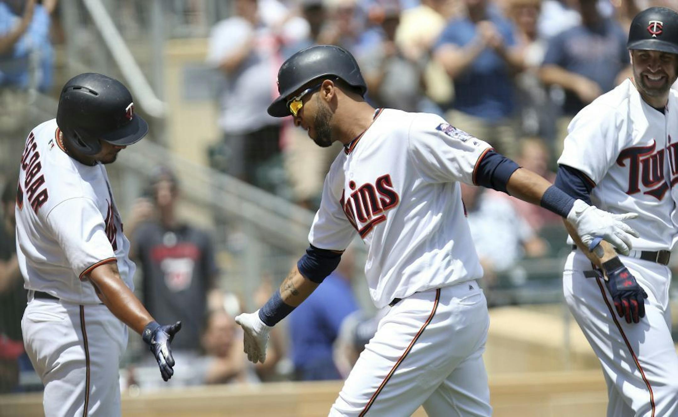 Minnesota Twins' Eddie Rosario, middle, celebrates with teammate Eduardo Escobar, left, after Rosario's three-run home run in the fourth inning of a baseball game Thursday, June 7, 2018 in Minneapolis.