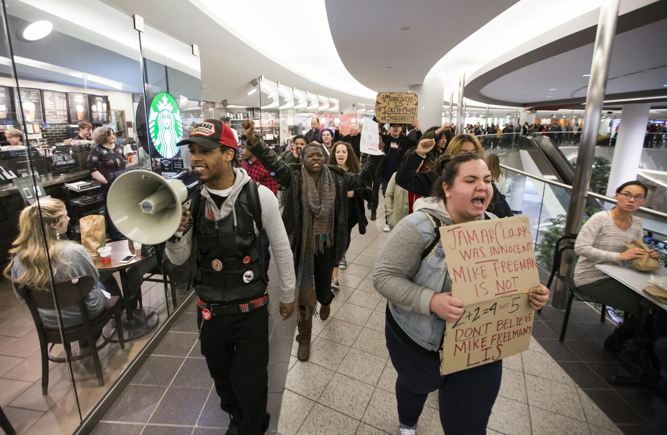 Alex Clark, left, a cousin of Jamar Clark, and Madeline Rivard lead a "Freeman Friday" march through the skyway.