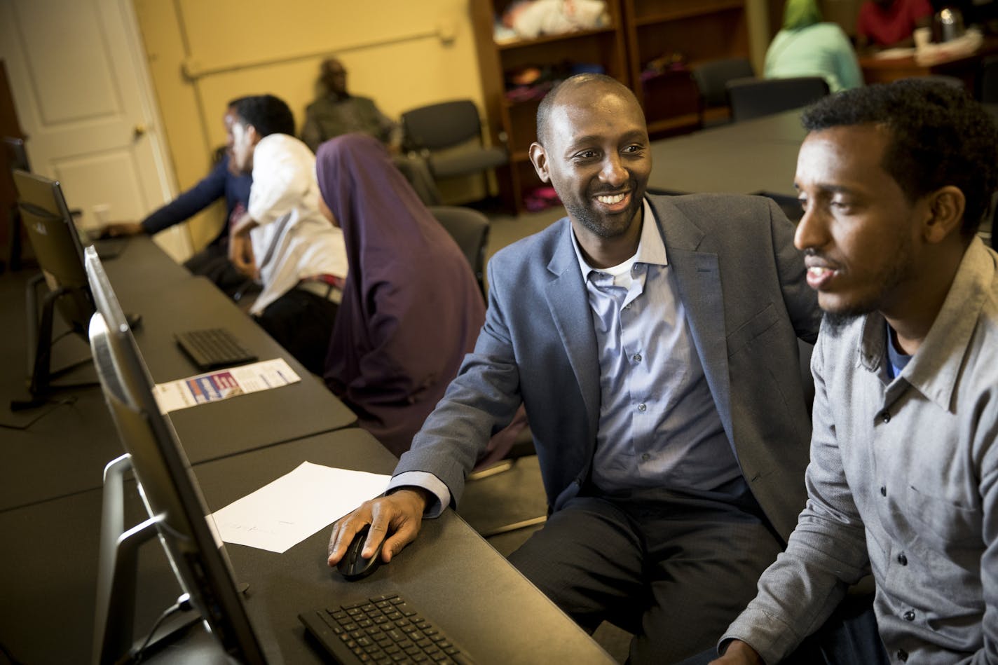 Mohamud Noor, left, helped Daud Abshir apply for a job at Amazon, in Minneapolis. "Why not combine our separate efforts and do a better collaborative effort?" said Noor, head of the Confederation of Somali Community, a coalition member.