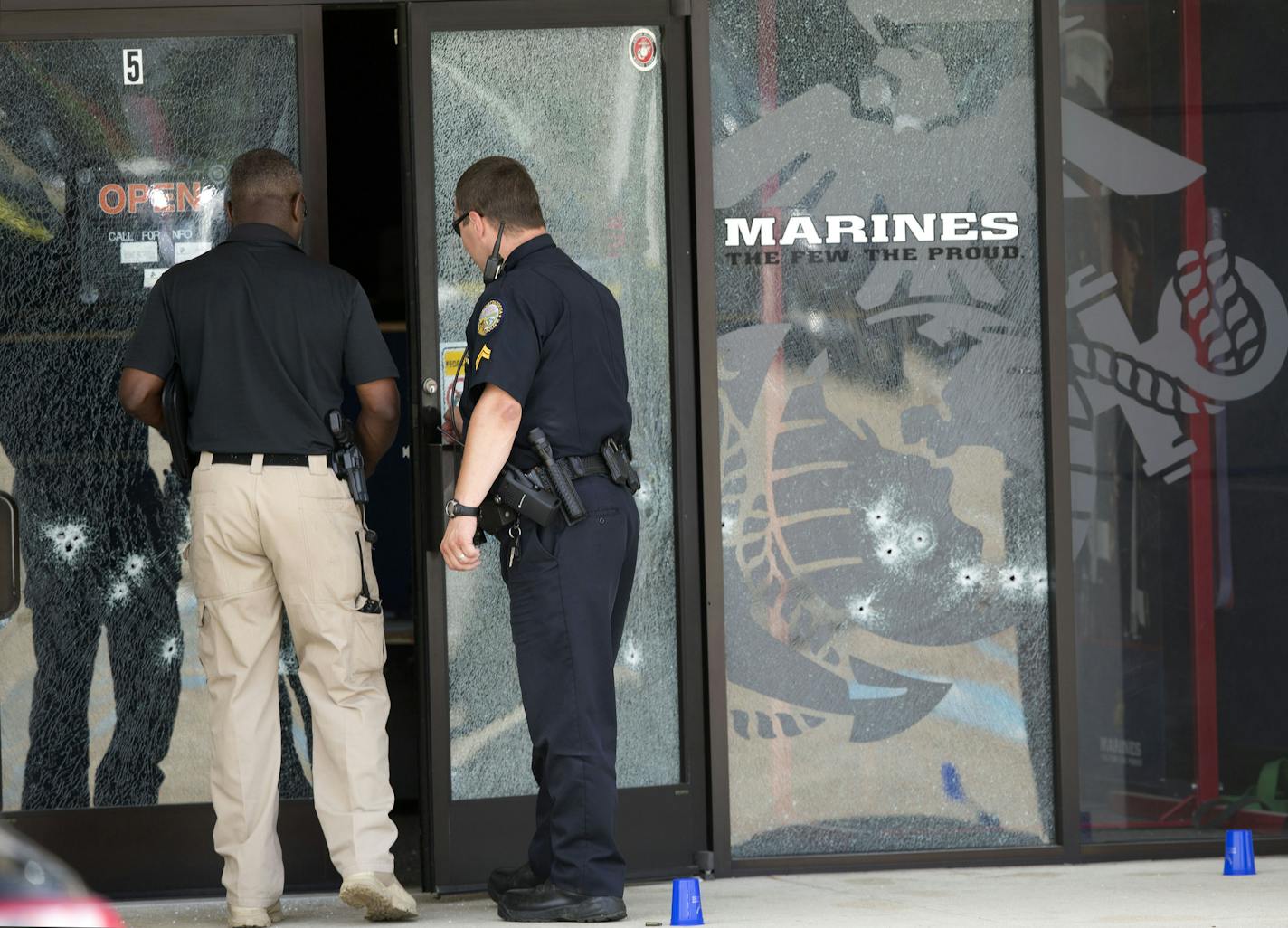 Police officers enter the Armed Forces Career Center through a bullet-riddled door after a gunman opened fire on the building Thursday, July 16, 2015, in Chattanooga, Tenn. Authorities say there were multiple casualties including the gunman. (AP Photo/John Bazemore)