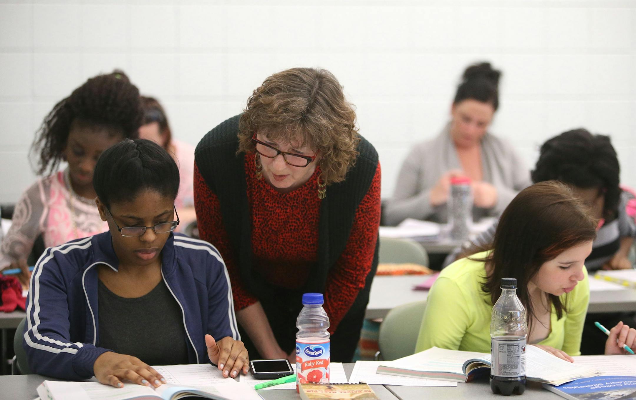 Laurel Watt is worried that proposed legislation would eliminate classes like her developmental reading class at Inver Hills Community College, that teach reading skills to struggling students -- half of the students in her class who are non-native English speakers. Here, Watt assists Nickole Fevrier, a freshman, on comprehending text book reading Tuesday, March 17, at Inver Hills Community College in Inver Grove Heights, MN.