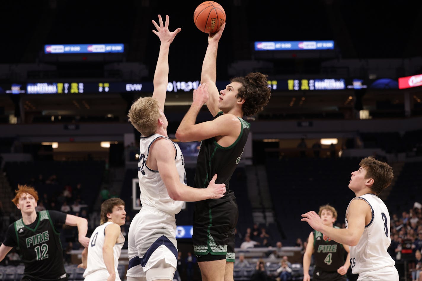 Holy Family's Boden Kapke (33) shoots a short jump shot over Eden Valley-Watkins' defender Noah Stommes (23). Kapke led the Fire's scoring with 26 points. Photo by Cheryl A. Myers, SportsEngine