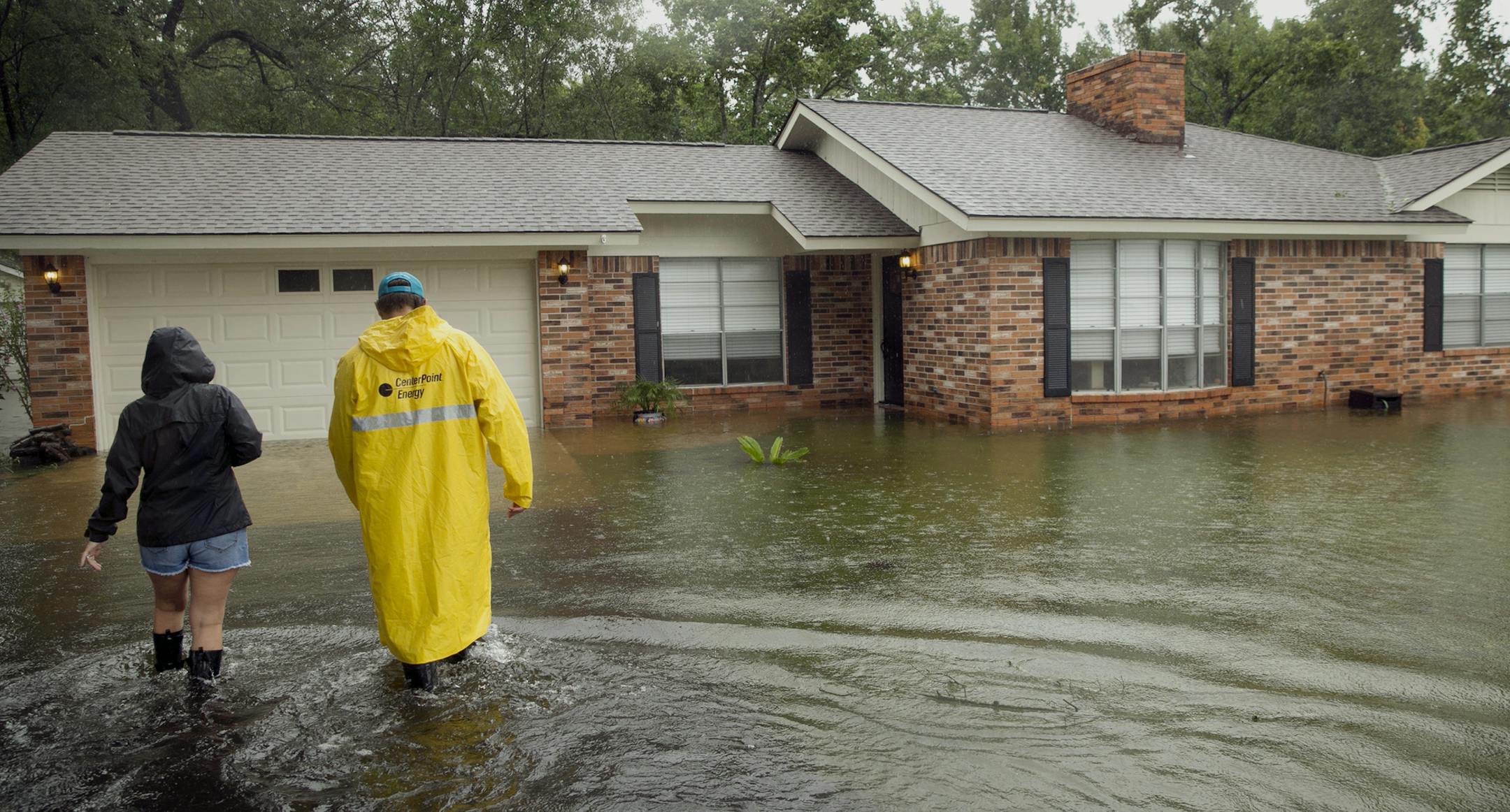 Warren and Denee Wehr walk to their flooded home in Smithville, Texas, Sunday, Aug. 27, 2017. Harvey made landfall in Texas on Friday night as the strongest hurricane to hit the U.S. in more than a decade. By Saturday afternoon it had been downgraded into a tropical storm, but it had dumped over a dozen inches of rain on some areas and forecasters were warning that it could cause catastrophic flooding in the coming days. (Jay Janner/Austin American-Statesman via AP)