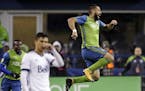 Seattle Sounders' Clint Dempsey leaps after scoring the first of his two goals against the Vancouver Whitecaps, during the second half of the second l