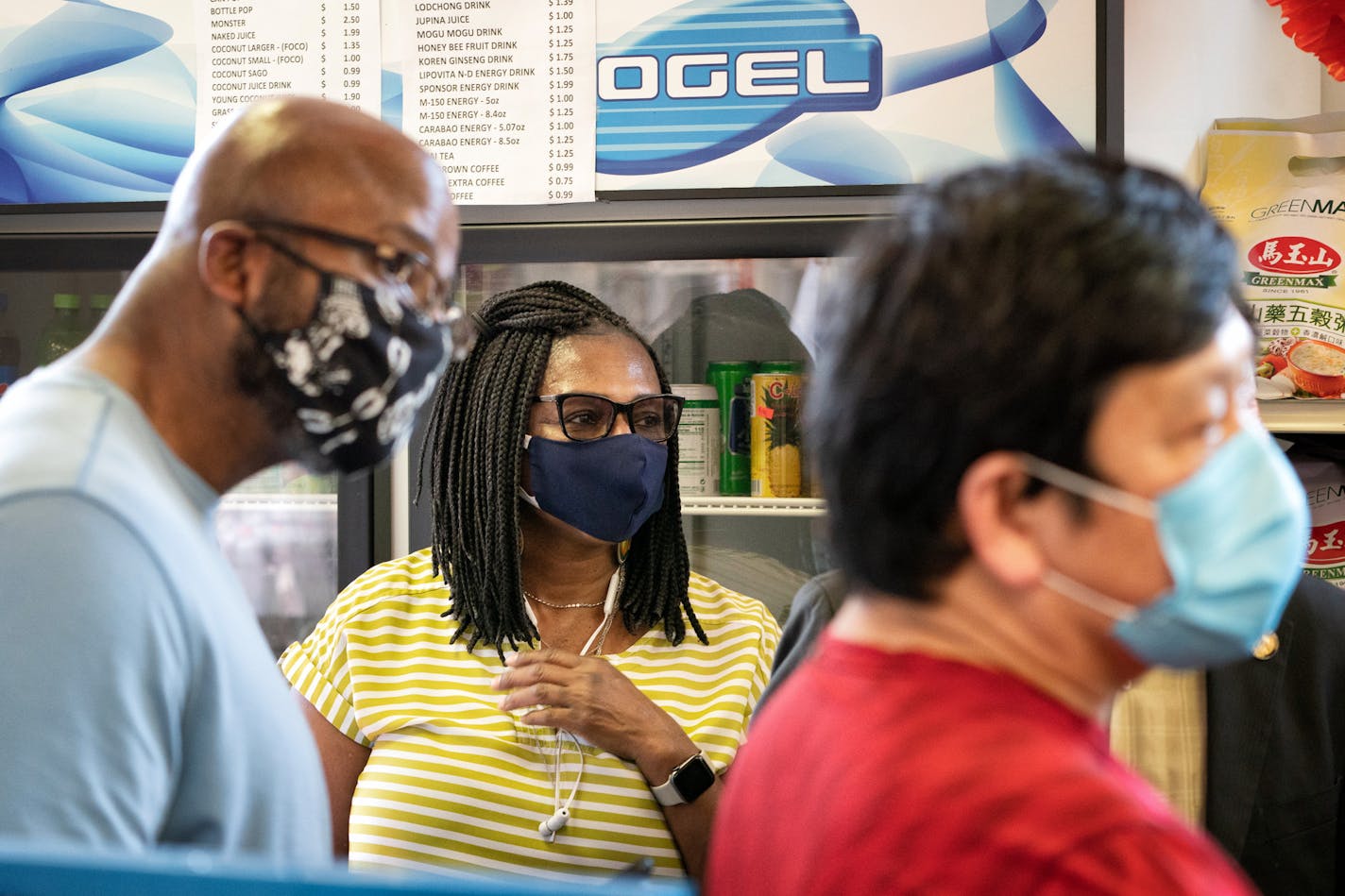 Rep. Rena Moran, DFL-St. Paul, listened as Gov. Tim Walz talked with May's Market owner May Yang, right, in St Paul on June 8.