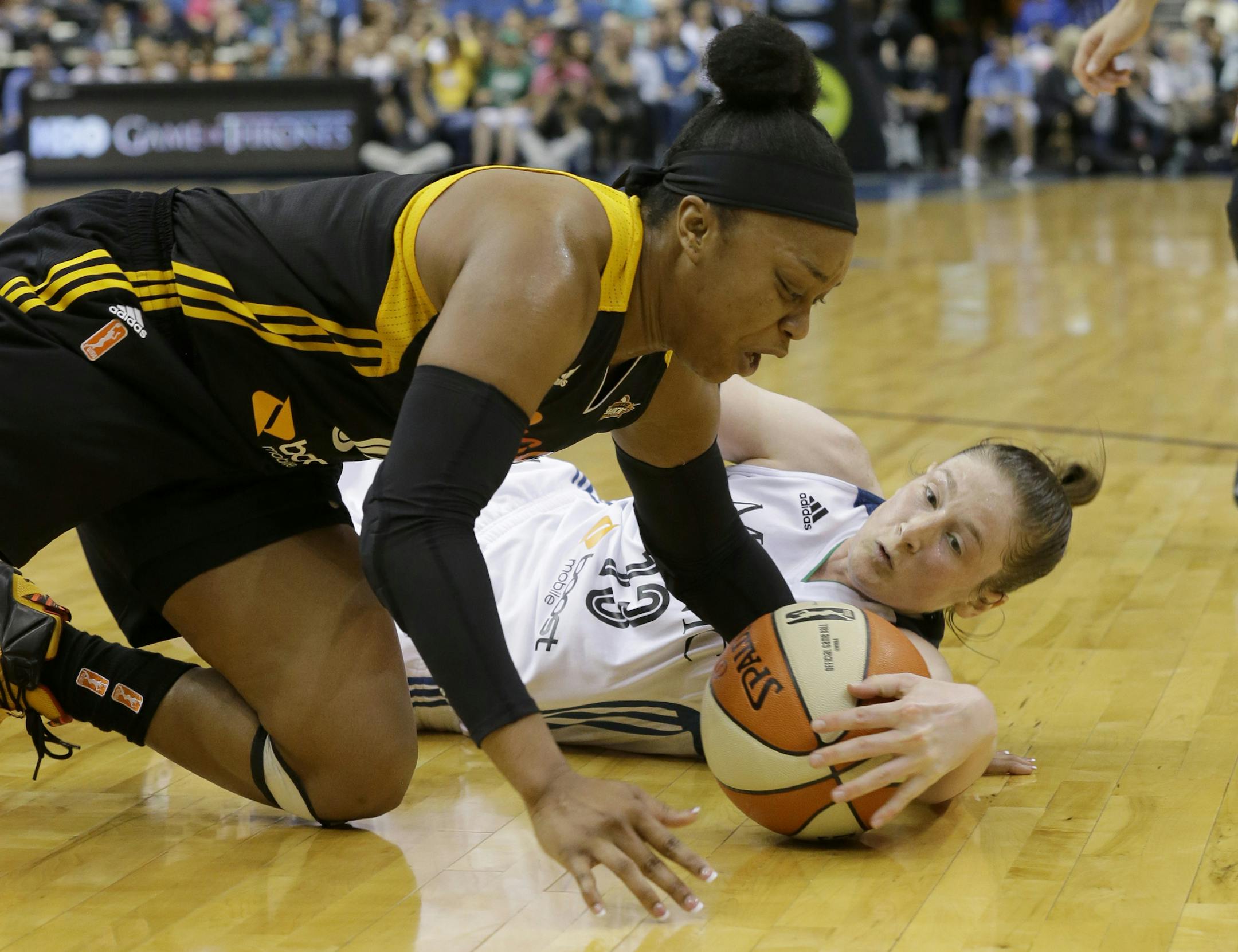 Tulsa Shock guard Odyssey Sims, left, and Minnesota Lynx guard Lindsay Whalen, right, battle for a loose ball during the first half of a WNBA basketball game in Minneapolis, Friday, June 5, 2015. (AP Photo/Ann Heisenfelt)