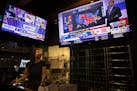 Bartender Sam Schilke watches election results on television at a bar and grill Tuesday, Nov. 3, 2020, in Portland, Ore. (AP Photo/Paula Bronstein)