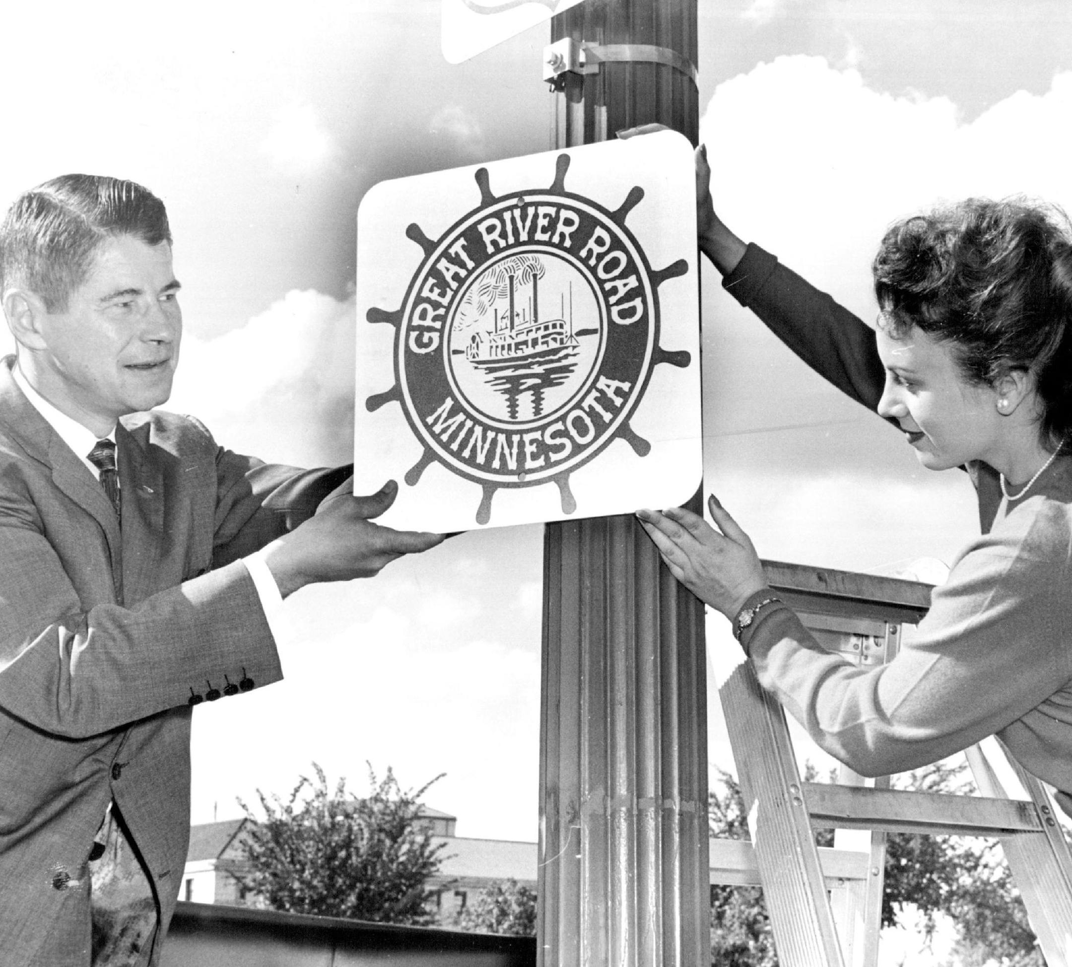 September 17, 1959 The First Sign - Gov. Orville Freeman helped Valora Allen, Miss Minnesota Highways, put up the first road marker and emblem for the Missisippi parkway Wednesday, near the Minnesota capitol. Some 1,000 of the signs will be installed in Minnesota along the parkway route. The highway extends from Canada to the Gulf of Mexico, and will open the Northwest Angle of Minnesota to automobile traffic when it is completed. Miss Allen, who lives at 1134 Edgerton St., St. Paul, is a clerk