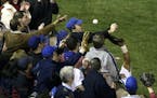 ** FILE ** In this Oct. 14, 2003 file photo, Chicago Cubs left fielder Moises Alou's arm is seen reaching into the stands, at right, unsuccessfully fo