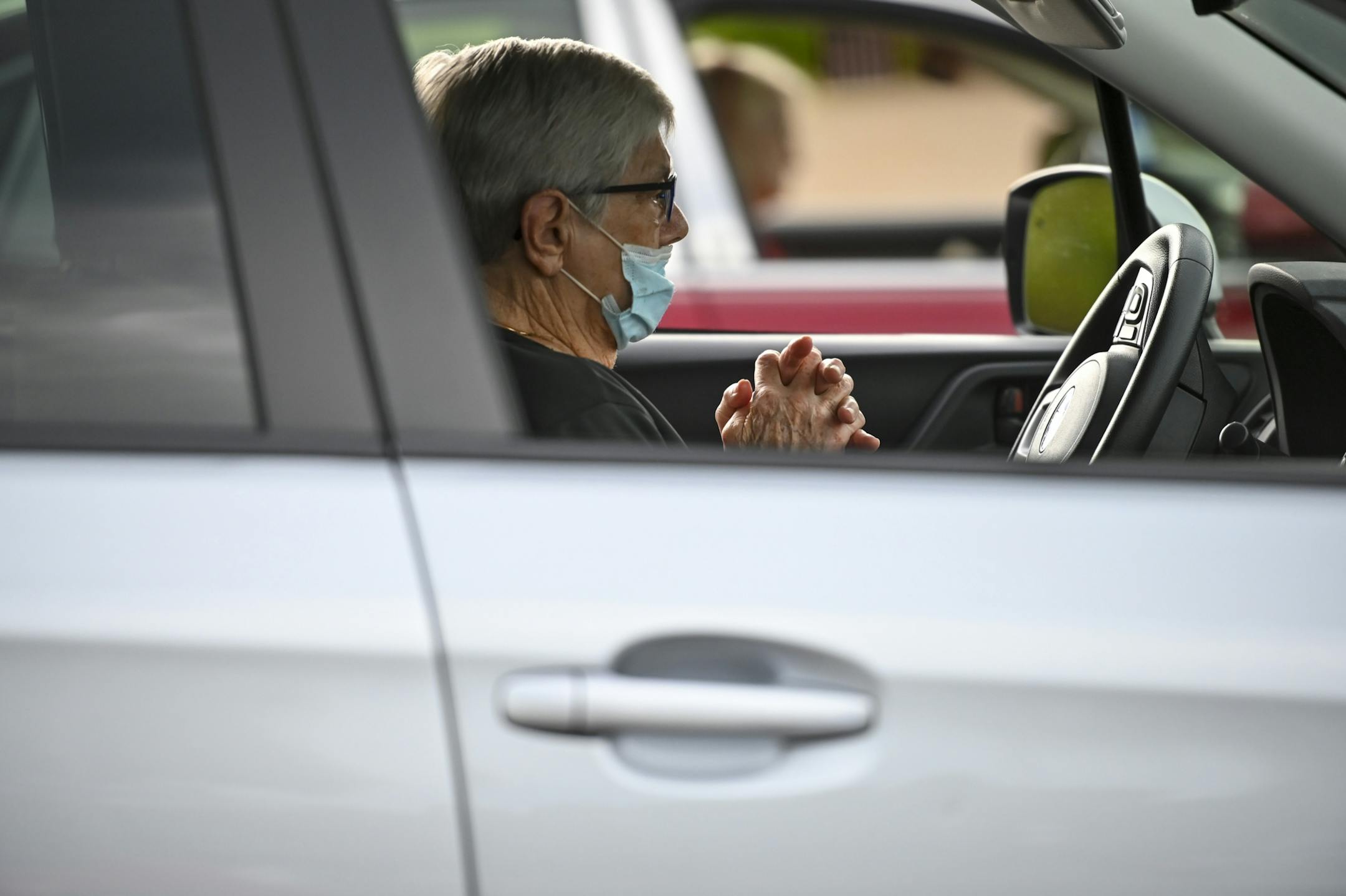 Kaye Sauer, 88, of Maplewood, prayed in her car during Transformation Church's evening mass Wednesday. Sauer says she's been coming to the church for 50 years, but due to recent health issues, she's been attending mass in her car or virtually. "We'll go with the flow" she said of her church's evolving circumstances with the pandemic.