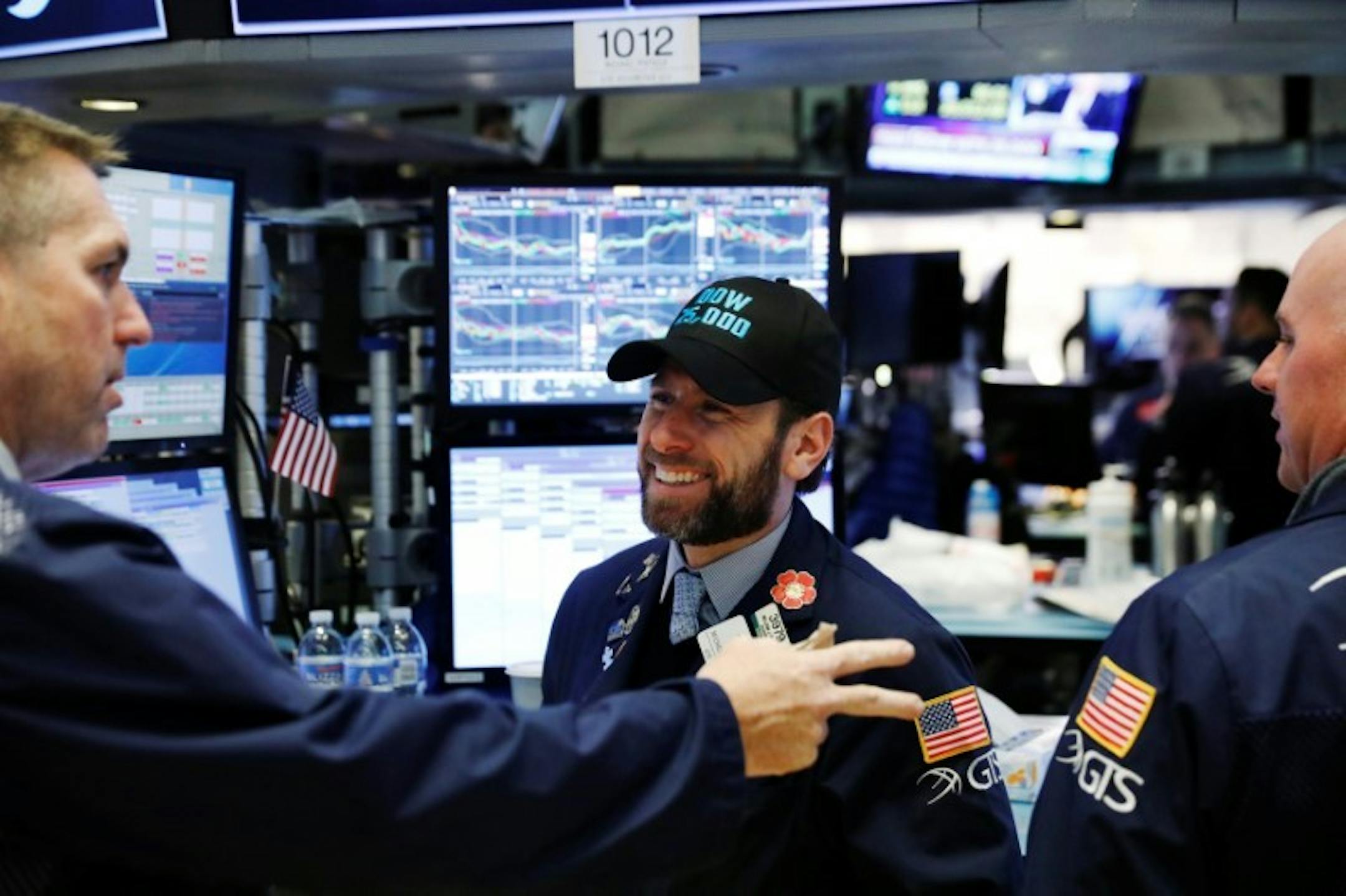 Traders laugh as the Dow Jones Industrial Average rises above 25,000 on the floor of the New York Stock Exchange shortly after the opening bell in New York, U.S., January 4, 2018. REUTERS/Lucas Jackson