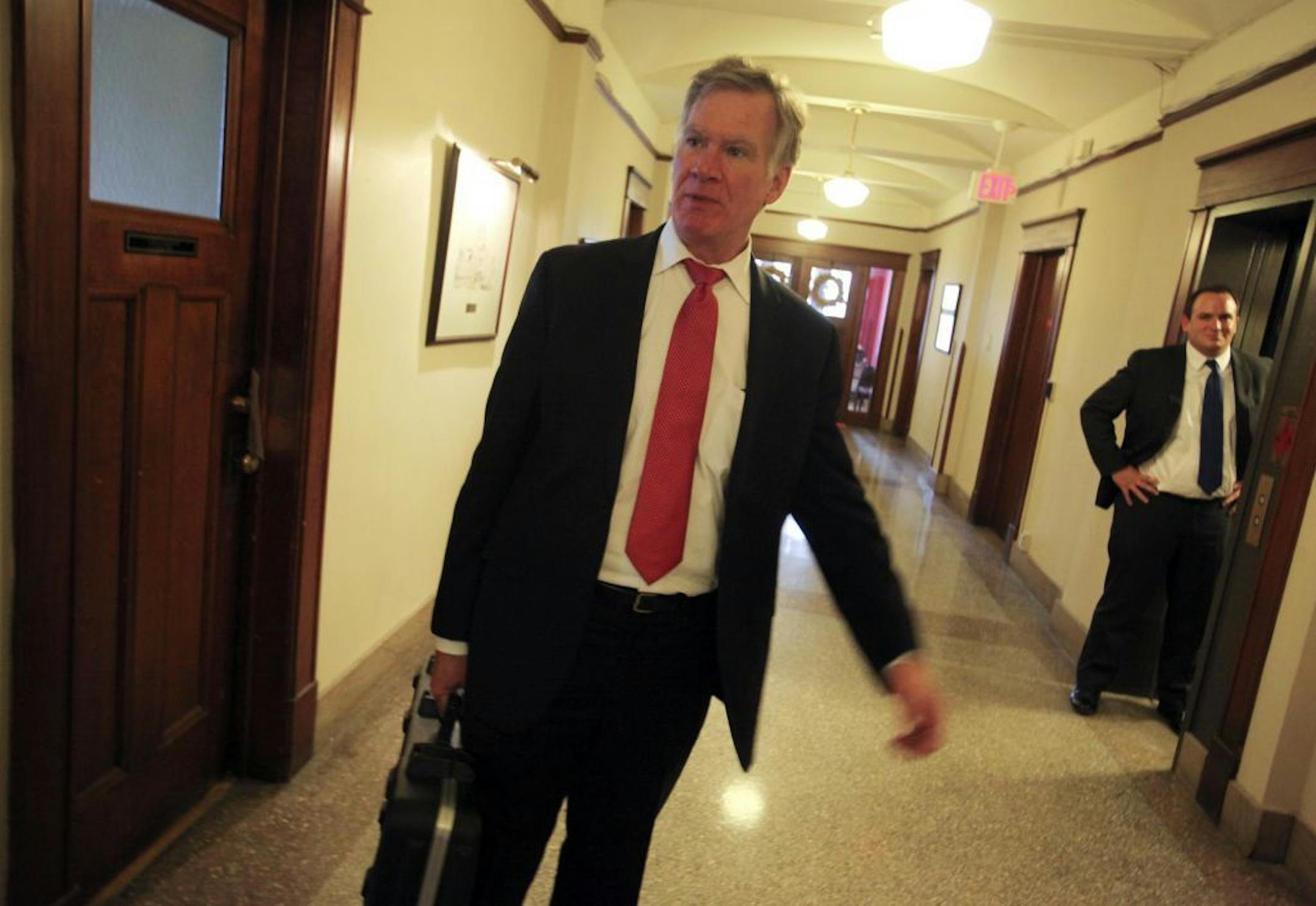With guitar case in hand, St. Paul mayor Chris Coleman headed out from guitar practice Wednesday, Jan. 30, 2013, in St. Paul, MN, as his communications director Joe Campbell, right, waited.