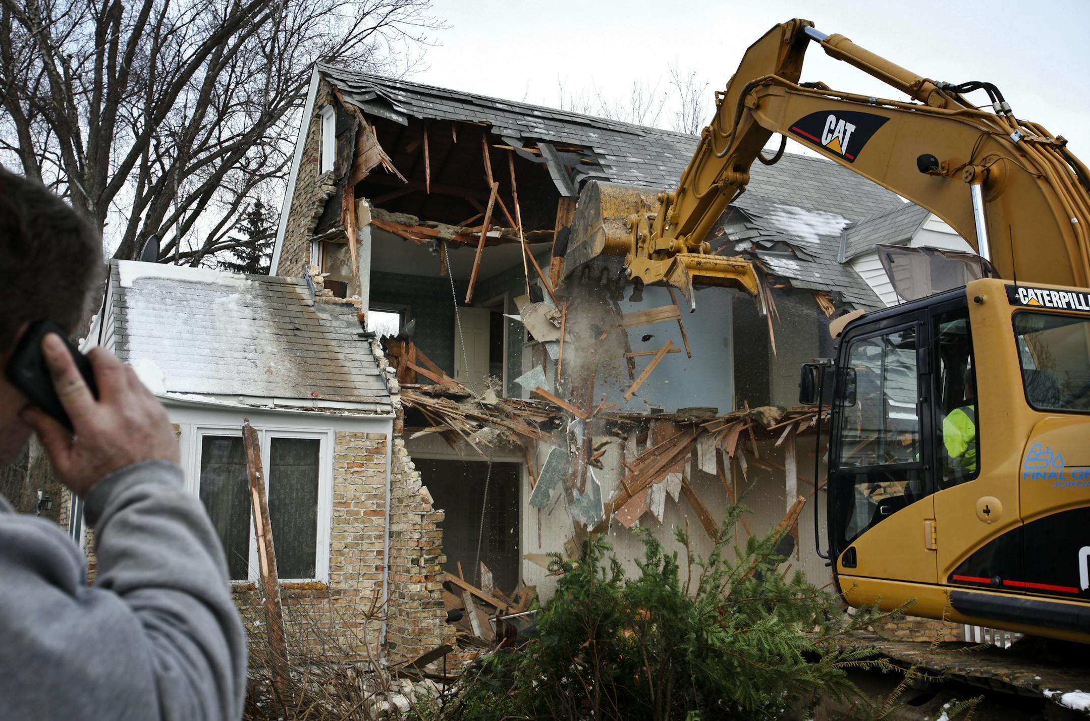 A backhoe operator from Final Grade worked on knocking down a cape cod homeThursday, Feb. 23, 2012, in Edina, MN, in order to build a new home on the lot for a family moving to Edina from Seattle.] DAVID JOLES*djoles@startribune.com - A cape cod home was torn down in the 5300 block of Kellog Ave. Thursday in Edina, which had a record number of tear downs in 2011 and is on pace to break that record.