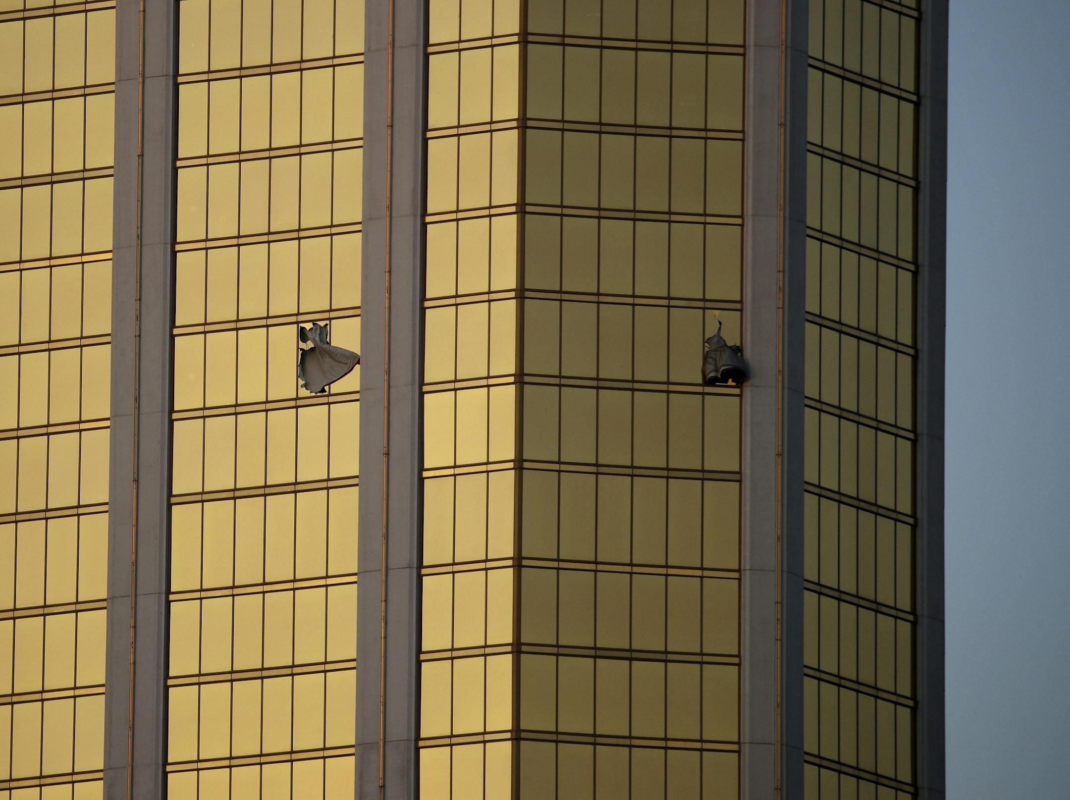 Drapes billow out of broken windows at the Mandalay Bay resort and casino Monday following a deadly shooting at a music festival in Las Vegas. A gunman was found dead inside a hotel room.