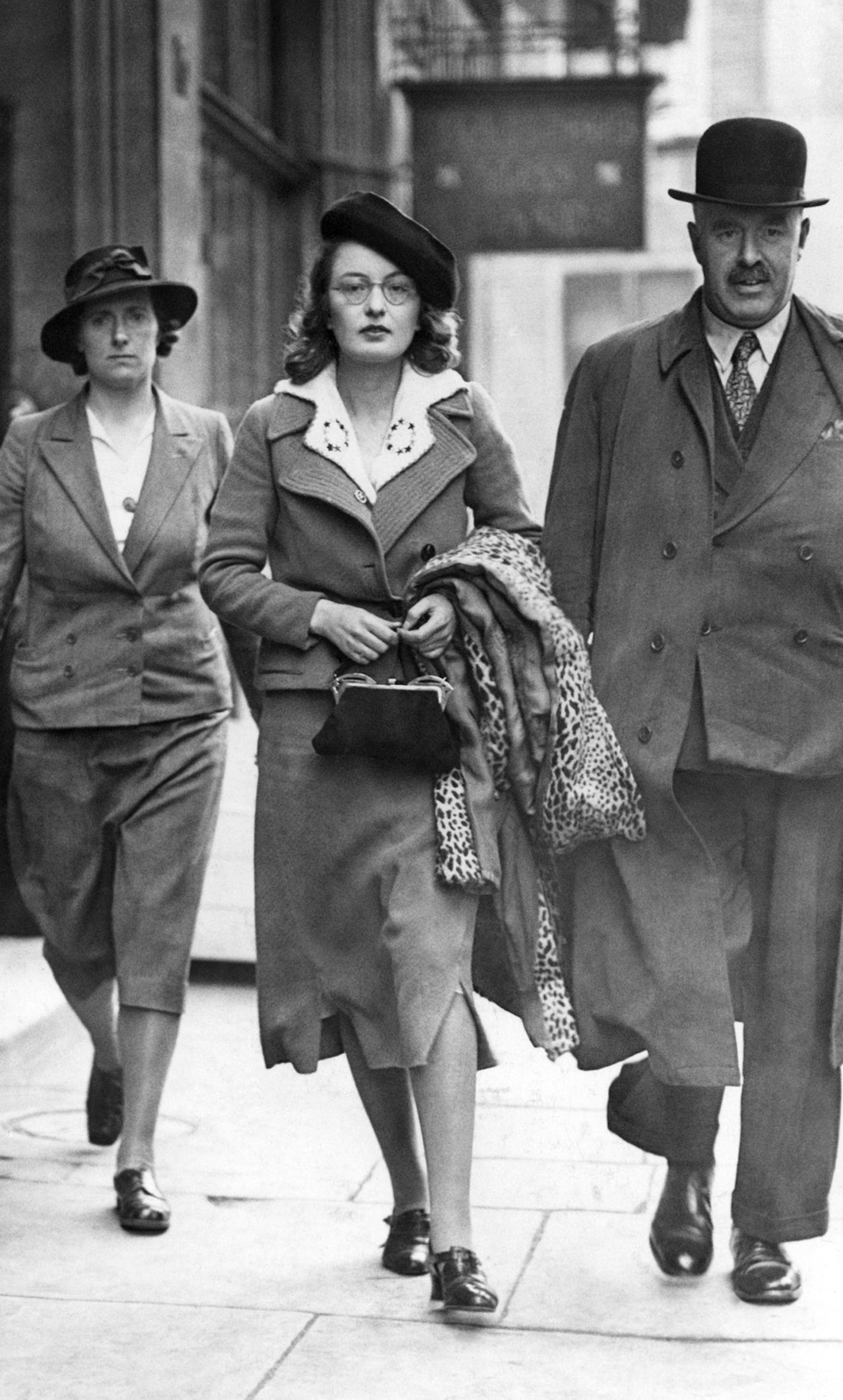 A woman fascist, center, being arrested at the Fascist headquarters in London on May 23, 1940. She is being lead away by a wardress and a plain clothes policeman. Plain clothes detectives made a raid on the headquarters of the British Union of Fascists searching the buildings and making some arrests. (AP Photo) ORG XMIT: APHS332383