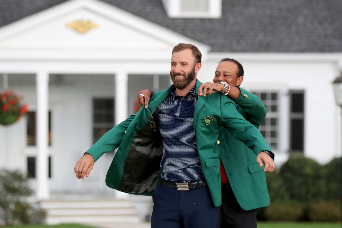 New Masters champion Dustin Johnson got his first green jacket from 2019 winner Tiger Woods after Johnson's record-setting performance at Augusta National on Sunday.