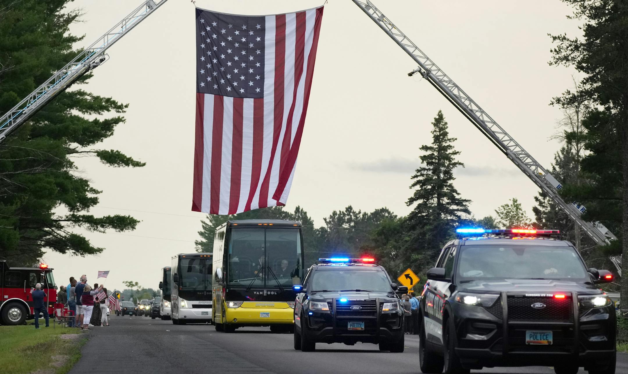 Fargo police vehicles passed beneath an American flag draped by fire trucks over Patriot Avenue as they escorted slain officer Jake Wallin and his family to Pequot Lakes High School&nbsp;for Saturday's funeral.