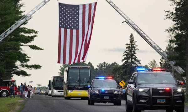 Fargo police vehicles passed beneath an American flag draped by fire trucks over Patriot Avenue as they escorted slain officer Jake Wallin and his fam