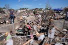 Family members clean belongings out of a tornado damaged home, Thursday, May 23, 2024, in Greenfield, Iowa.