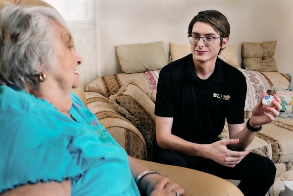 Geek Squad agent Michael Duvall educates Margaret, 89, of Moosic, Pa., about a wearable device that monitors vital signs. 