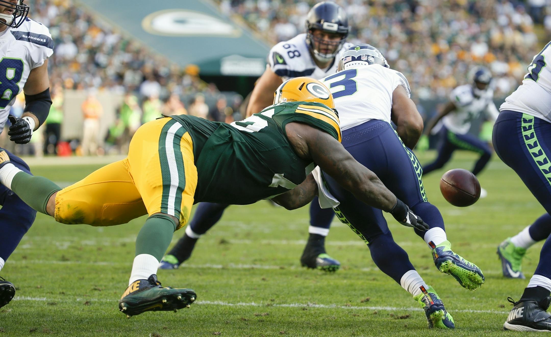 Green Bay Packers' Mike Daniels causes Seattle Seahawks' Russell Wilson to fumble during the second half of an NFL football game Sunday, Sept. 10, 2017, in Green Bay, Wis. The Packers recovered the ball. (AP Photo/Mike Roemer)