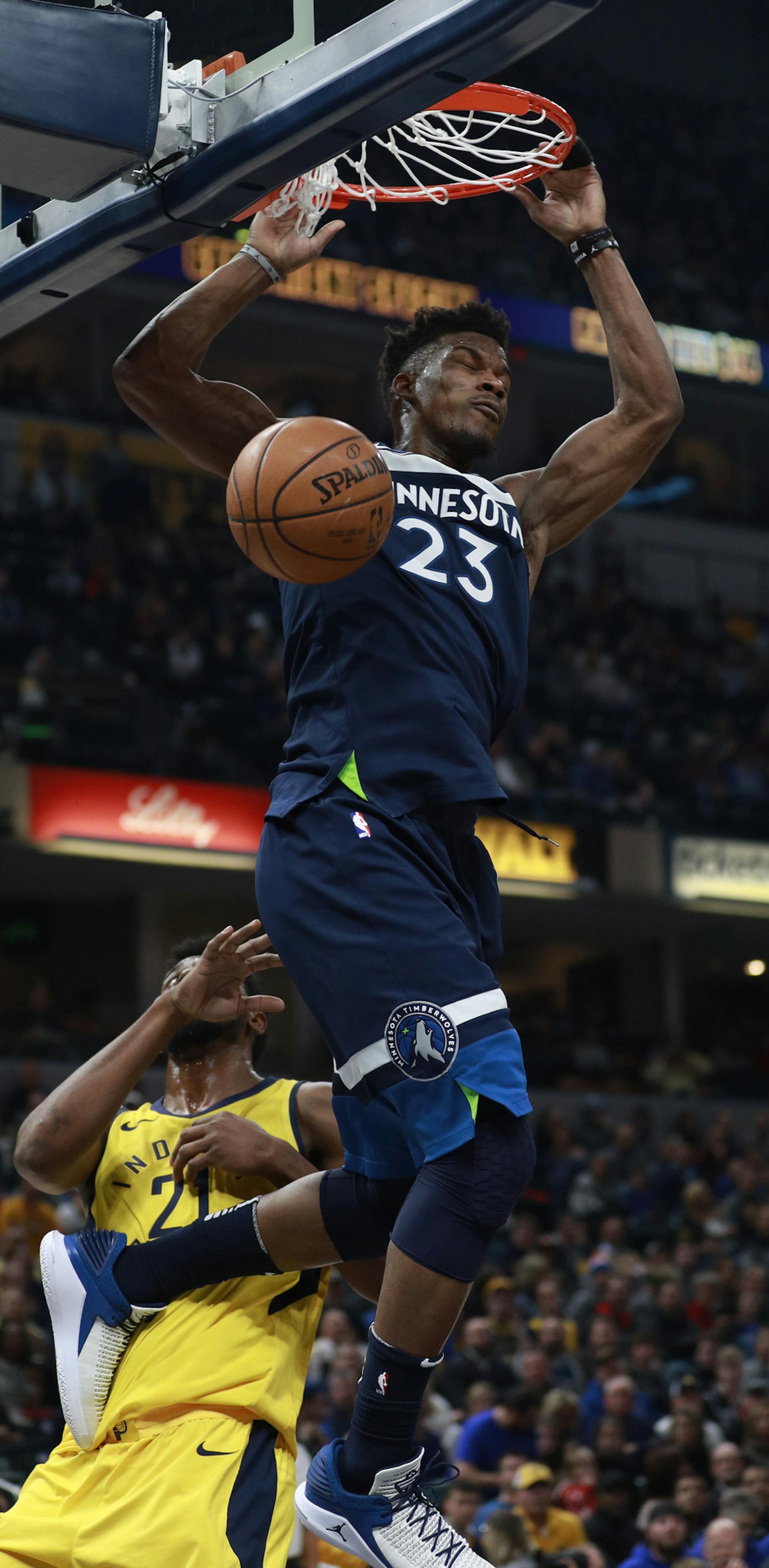 Minnesota Timberwolves guard Jimmy Butler (23) dunks while defended by Indiana Pacers forward Thaddeus Young in the first half of an NBA basketball game, Sunday, Dec. 31, 2017, in Indianapolis. (AP Photo/R Brent Smith)