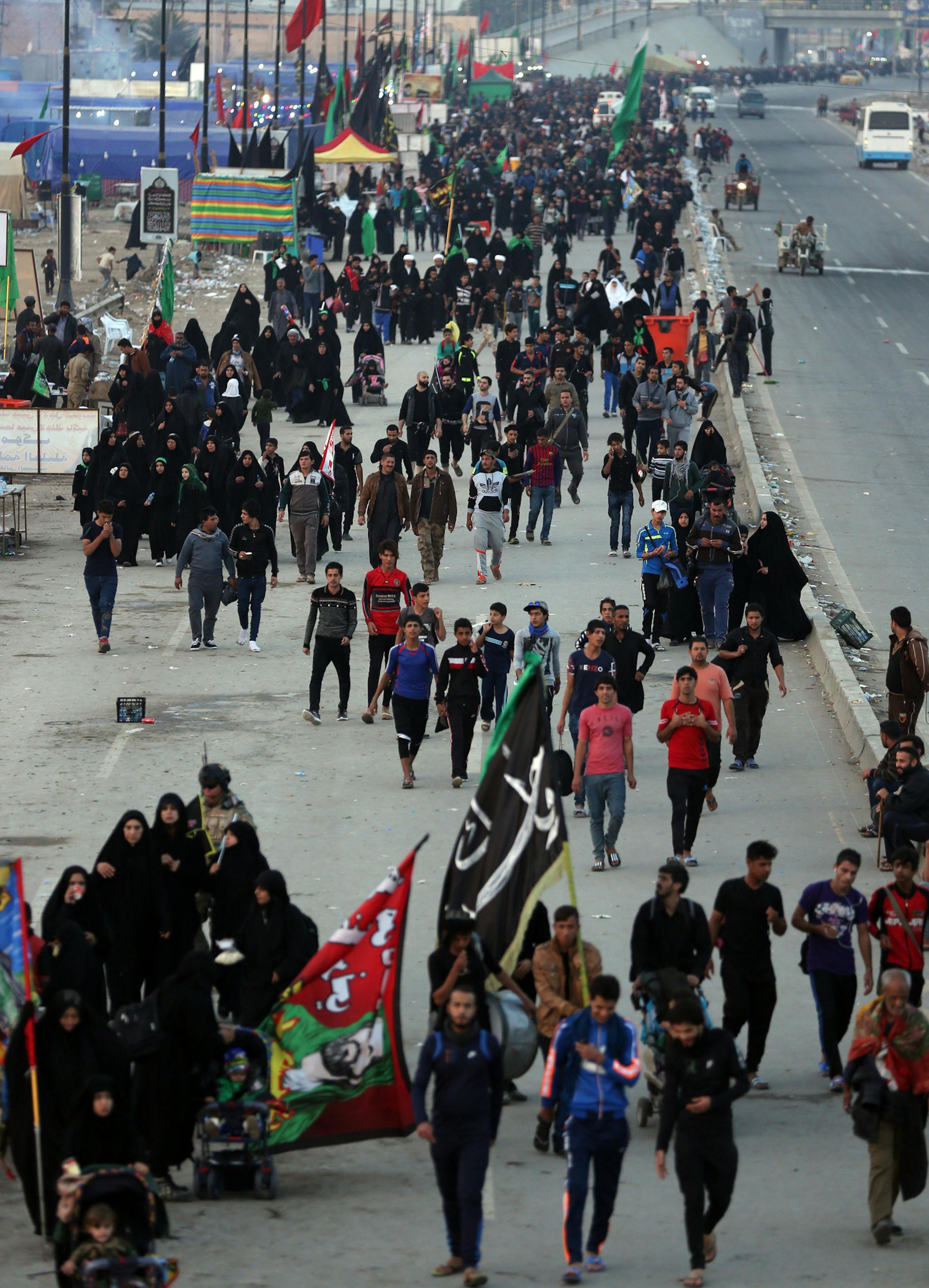 Shiite pilgrims march to Karbala during the Arbaeen ritual in Baghdad, Iraq, Sunday, Nov. 29, 2015. The holiday marks the end of the forty day mourning period following the anniversary of the 7th century martyrdom of Imam Hussein, the Prophet Muhammad's grandson. (AP Photo/Hadi Mizban)