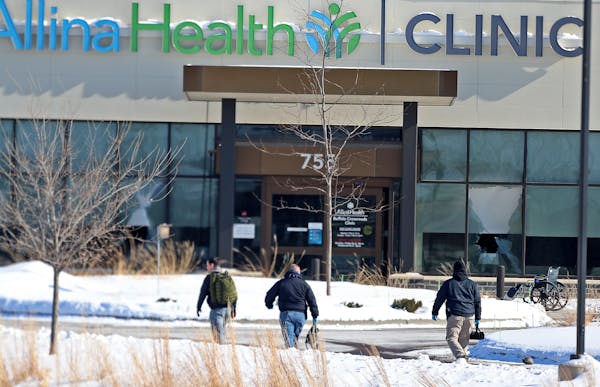 Law enforcement personnel walk toward the Allina Health clinic on Tuesday, Feb. 9, 2021, in Buffalo, Minn. Authorities say multiple people were shot a